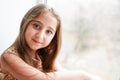 Happy little girl a on white background sitting on the window sill Royalty Free Stock Photo