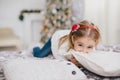 Happy little girl in a white sweater and blue jeans posing near christmas tree Royalty Free Stock Photo