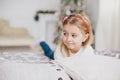 Happy little girl in a white sweater and blue jeans posing near christmas tree Royalty Free Stock Photo