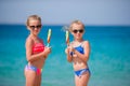 Happy little girls eating ice-cream on the beach.