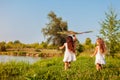 Happy little girls with kite running on meadow in spring park. Children having fun playing outdoors Royalty Free Stock Photo