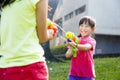 Happy little girls playing water guns in the park