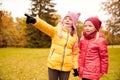 Happy little girls pointing finger in autumn park Royalty Free Stock Photo