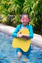 Happy little girls in swimsuits standing with kickboard in the swimming pool Royalty Free Stock Photo