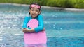 Happy little girls in swimsuits standing with kickboard in the swimming pool Royalty Free Stock Photo