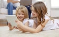 Happy little girls with tablet pc computer at home Royalty Free Stock Photo