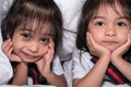 Happy little girls twins sister in bed under the blanket having fun, smiling and wacky Royalty Free Stock Photo