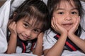 Happy little girls twins sister in bed under the blanket having fun, smiling and wacky Royalty Free Stock Photo