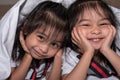 Happy little girls twins sister in bed under the blanket having fun, smiling and wacky Royalty Free Stock Photo