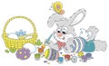 Happy little grey bunny painting ornate Easter eggs