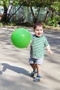 Happy little handsome boy holds green balloon and smiles Royalty Free Stock Photo