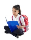 Happy little hispanic female school child reading book in stress and upset