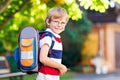 Happy little kid boy with glasses and backpack or satchel on his first day to school or nursery. Child outdoors on warm Royalty Free Stock Photo