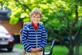 Happy little kid boy with glasses and backpack or satchel on his first day to school or nursery. Child outdoors on warm Royalty Free Stock Photo