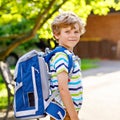 Happy little kid boy with glasses and backpack or satchel on his first day to school or nursery. Child outdoors on warm Royalty Free Stock Photo