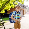 Happy little kid boy with glasses and backpack or satchel on his first day to school or nursery. Child outdoors on warm Royalty Free Stock Photo