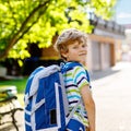 Happy little kid boy with glasses and backpack or satchel on his first day to school or nursery. Child outdoors on warm Royalty Free Stock Photo