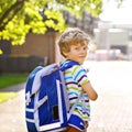 Happy little kid boy with glasses and backpack or satchel on his first day to school or nursery. Child outdoors on warm Royalty Free Stock Photo