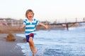 Happy little kid boy having fun with running through water in ocean Royalty Free Stock Photo