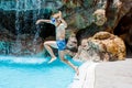 Happy little kid boy jumping in the pool and having fun on family vacations in a hotel resort. Healthy child playing in Royalty Free Stock Photo