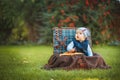 Happy little kid boy playing with airplane toy while sitting in suitcase on green autumn lawn. Children enjoying activity outdoor Royalty Free Stock Photo