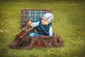 Happy little kid boy playing with airplane toy while sitting in suitcase on green autumn lawn. Children enjoying activity outdoor Royalty Free Stock Photo