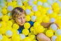 Happy little kid boy playing at colorful plastic balls playground high view. Adorable child having fun indoors Royalty Free Stock Photo