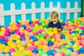 Happy little kid boy playing at colorful plastic balls playground high view. Funny child having fun indoors Royalty Free Stock Photo