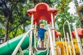 Happy little kid boy playing at colorful playground. Adorable child having fun outdoors Royalty Free Stock Photo