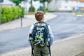 Happy little kid boy with satchel and eyeglasses. Schoolkid wearing glasses on the way to middle or high school. Excited