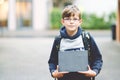 Happy little kid boy with satchel and eyeglasses. Schoolkid wearing glasses on the way to middle or high school. Excited