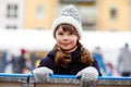 Happy little kid girl in colorful warm clothes skating on a rink of Christmas market or fair. Healthy child having fun Royalty Free Stock Photo