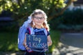 Happy little kid girl with eye glasses with backpack or satchel and big school bag on the first day of school. Healthy Royalty Free Stock Photo