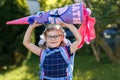 Happy little kid girl with eye glasses with backpack or satchel and big school bag or gift cone traditional in Germany Royalty Free Stock Photo