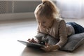 Happy little kid girl playing online games on tablet. Royalty Free Stock Photo