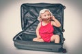Happy little kid inside suitcase - retro style