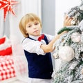 Happy little kid laughing at the tree. The concept of Christmas Royalty Free Stock Photo