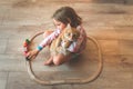 Happy little kid play with toy wooden train railway at home together with pet cat. Toys for children in kindergarten and Royalty Free Stock Photo