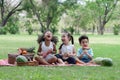 Happy little kids African, Caucasian and Asian picnic in the park. They laughing and sitting on grass eating watermelon Royalty Free Stock Photo