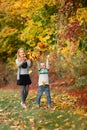 Happy little kids with autumn leaves in the park