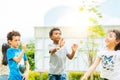 Happy little kids blowing soap bubbles in summer park. Kid and friends in international preschool play a bubble.