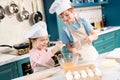 happy little kids in chef hats and aprons preparing dough together Royalty Free Stock Photo