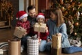 Happy little kids opening Christmas gifts with parents. Royalty Free Stock Photo