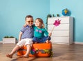 Happy little kids sitting on colorful orange suitcase prepared for family summer vacation. Young travelers. Little girl Royalty Free Stock Photo