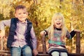 Happy Little Kids Sitting on a Wooden Garden Fence Royalty Free Stock Photo