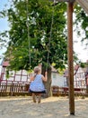 Happy little preschool girl having fun on swing on city outdoor playground. Healthy toddler child swinging on sunny Royalty Free Stock Photo