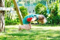 Happy little preschool girl having fun on swing in domestic garden. Healthy toddler child swinging on sunny summer day Royalty Free Stock Photo