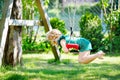 Happy little preschool girl having fun on swing in domestic garden. Healthy toddler child swinging on sunny summer day Royalty Free Stock Photo