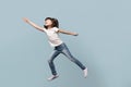 Happy little preschool girl jumping on blue background. Royalty Free Stock Photo