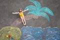 Happy little preschool girl in swimsuit on inflatable ring with sea, sand, palm painted with colorful chalks on asphalt